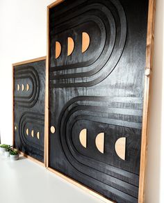 two black and white paintings on a wall