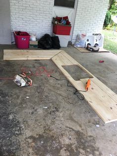 some wood is laying on the ground in front of a door and wires are plugged into it