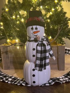 a snowman is standing in front of a christmas tree