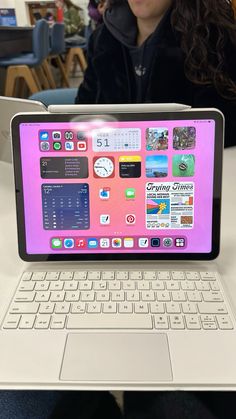 a laptop computer sitting on top of a white table next to a woman in a black jacket