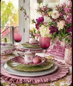 the table is set with pink and green dishes