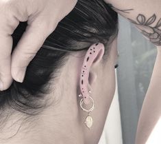 a woman wearing pink ear cuffs and piercings