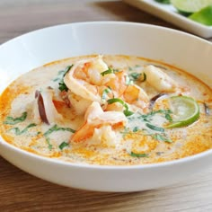 a white bowl filled with soup on top of a wooden table