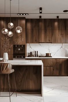 a modern kitchen with marble counter tops and wooden cabinetry, along with pendant lights