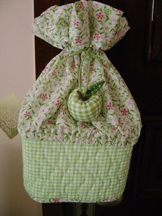 a green and white bag hanging from the side of a door with an apple on it