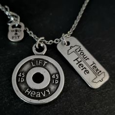 two personalized necklaces on a table with one saying lift here and the other saying if it is heavy