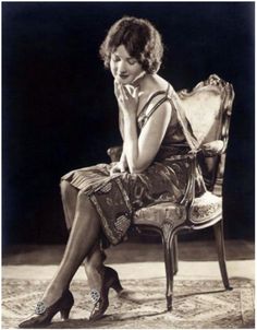 a woman sitting in a chair with her hand on her face