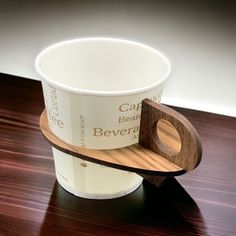 a cup holder with a wooden handle on a table