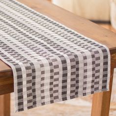 a wooden table topped with a black and white checkered table cloth on top of it