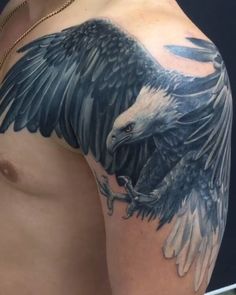 an eagle tattoo on the arm and chest is shown in black and grey colors with white accents