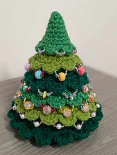 a small crocheted christmas tree sitting on top of a wooden table