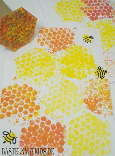 bees and honeycombs are painted on white paper with yellow, orange, and red circles