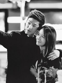 a man and woman taking a selfie in black and white with their arms around each other