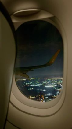 an airplane window looking out at the city lights