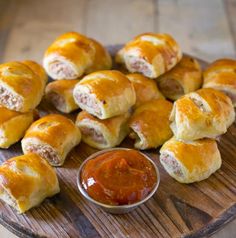 small pastries on a wooden platter with dipping sauce