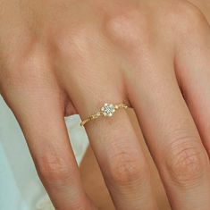 a woman's hand with a diamond ring on it