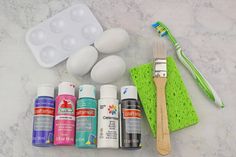 the supplies needed to make an easter egg decorating project are laid out on a marble countertop