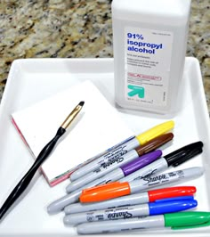 pens and markers are sitting on a tray next to a bottle of aeropopyl alcohol