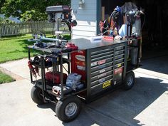 a small cart with tools on it in front of a garage