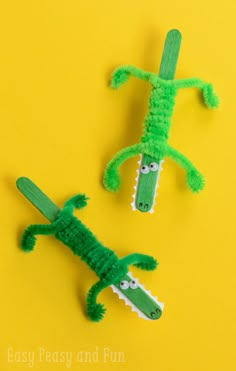 two plastic alligators are sitting next to each other on a yellow background with the words easy peasy and fun