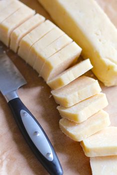 a knife and some cheese on a cutting board