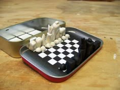 a chess board with white pieces on it and an open tin can in the background