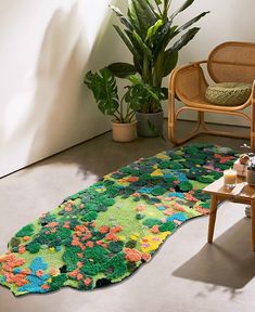 a living room with a rug on the floor next to a chair and potted plant