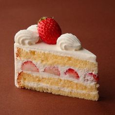 a piece of cake with white frosting and strawberries sitting on top of it