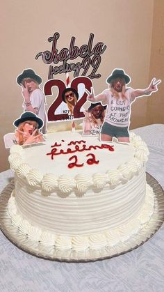 a white cake with two pictures on it and the number twenty five is displayed in front of an image of three people