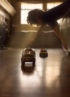 a child playing with toy cars on the floor