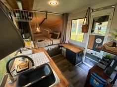 the interior of a tiny home with wood floors and walls, including a kitchen sink