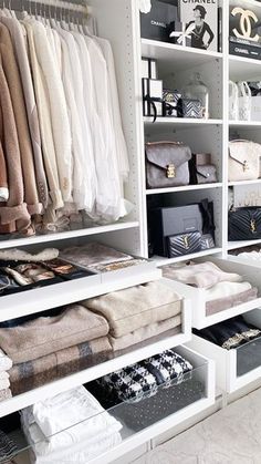 the closet is full of clothes and handbags, including one that has folded towels on it