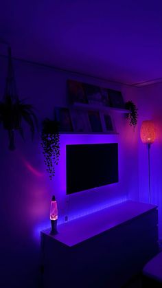 a room with purple lighting and a flat screen tv on the wall in front of it