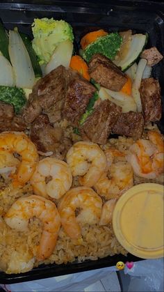 a tray filled with rice and shrimp next to broccoli