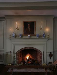 a living room with a fire place and painting on the wall above it's mantle