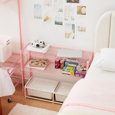 a bedroom with pink shelving and pictures on the wall