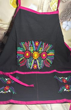 the apron is decorated with colorful flowers on it's front and back sides, along with other items