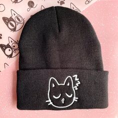 "Cute sleepy cat embroidered beanie, perfect for a cat lover looking for a fun way to express themselves! Make your hat unique by upgrading to the glow in the dark thread option! The Cat emoji caps are perfect for any occasion and would also make a great gift for a friend or relative! You could expect beautiful embroidery of our own hand drawn designs, embroidered by us, on a soft, high quality beanie! ☆ There may be a slight difference on every item that will make your items special and one of Casual Cat Design Beanie Hat, Casual Beanie Hat With Cat Design, Casual Beanie With Cat Design, Casual Knitted Beanie With Cat Ears, Casual Warm Beanie With Cat Ears, Casual Cat-ears Hat With Cat Design, Cute Fitted Beanie For Winter, Cute Fitted Winter Beanie, Cute Fitted Warm Beanie