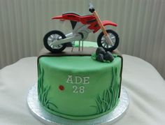 a green cake with a red motorcycle on top and the words age 28 printed on it