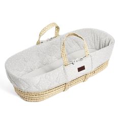 a baby bassinet that is made out of wicker and has white dots on it