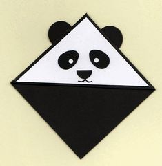 an origami panda bear with black and white triangles on it's face