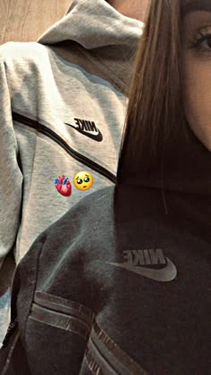 the girl is wearing a nike hoodie with embellishments on her chest