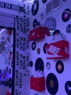 the wall is covered with various records, cds and nike shoes hanging on it's side