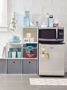 a microwave oven sitting on top of a refrigerator freezer next to storage bins