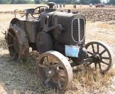 an old tractor sitting in the middle of a field