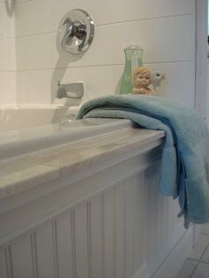 a white bath tub sitting next to a sink under a faucet