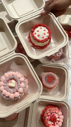 there are many cupcakes in the trays on the table and one is decorated with icing