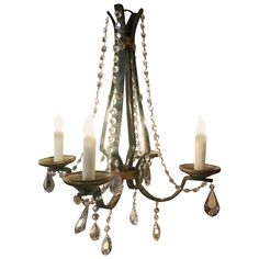 a chandelier with candles hanging from it's sides and beads on the bottom