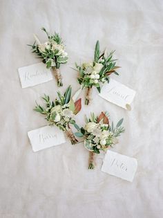 the wedding bouquets are laid out on top of each other, with tags attached to them