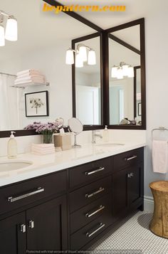 a bathroom with two sinks and mirrors on the wall above it is decorated in black and white